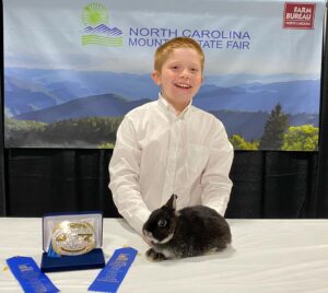 boy with his blue ribbon winning rabbit